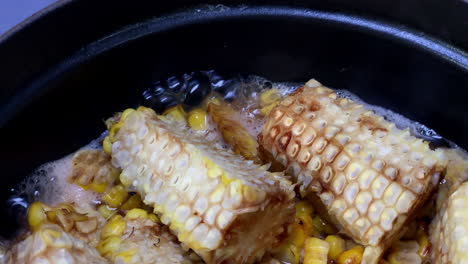 simmering rice with grilled kernels and corncob at home kitchen, tokyo, japan