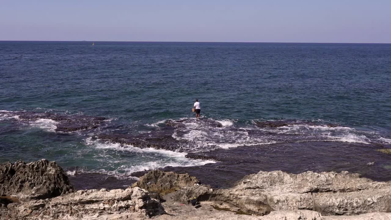 익명의 관광객 이  ⁇ 은 날 파도 있는 바다 를 감상 하고 있다