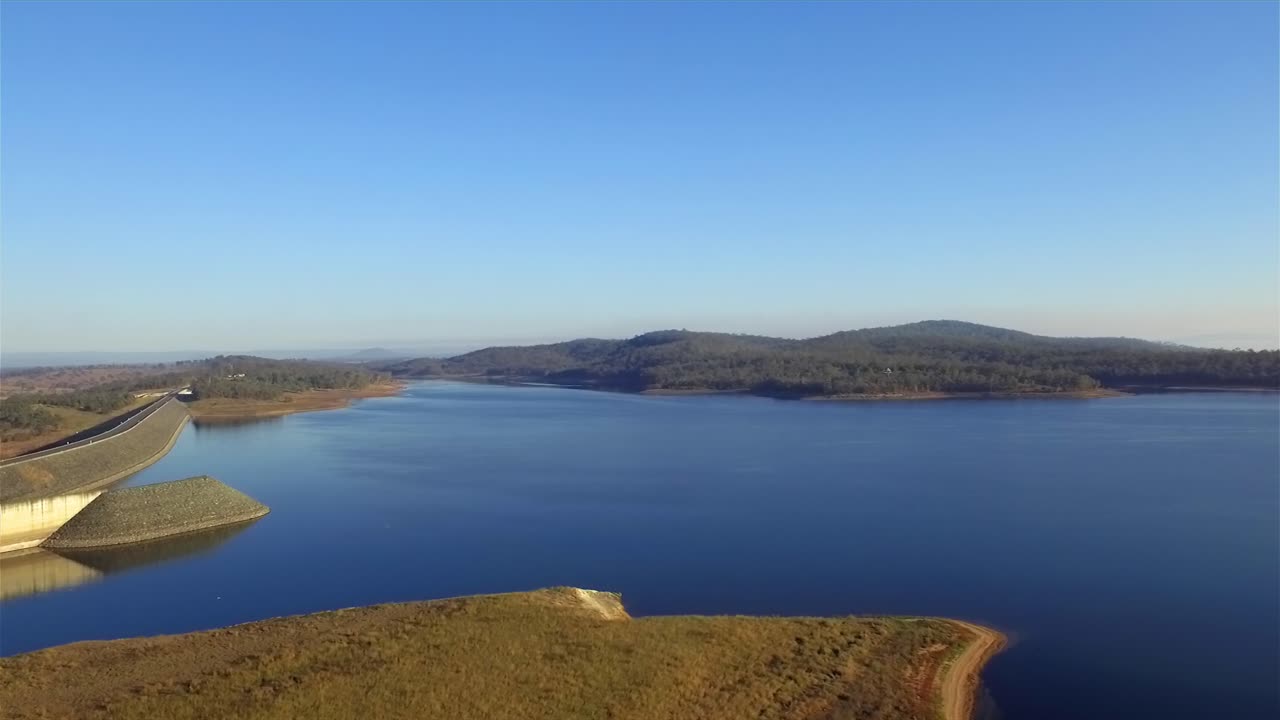 toma aérea, retirándose de la presa wivenhoe y recorriendo las tranquilas aguas azules del lago wivenhoe, en la pintoresca región de somerset en queensland
