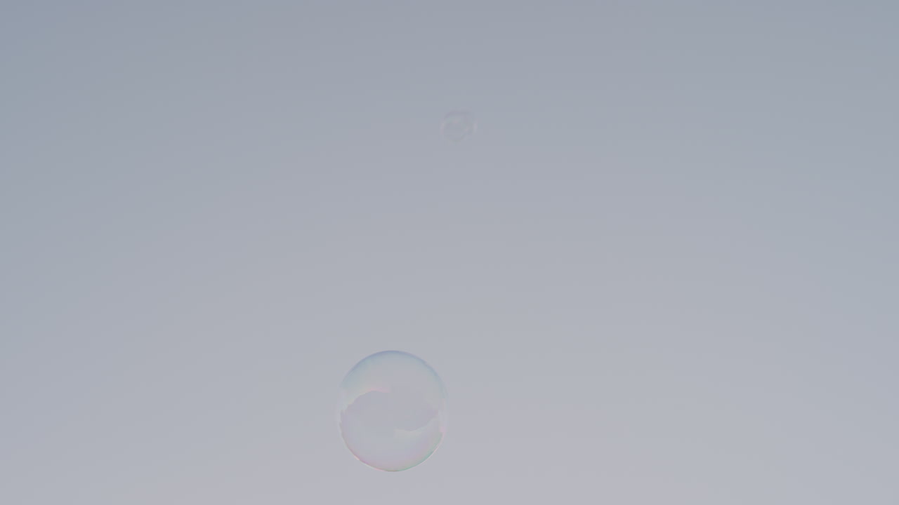 해가 지면 도시에서 부드럽게 떠다니는 다채로운 비누 거품