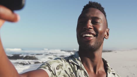 afroamericano tomando selfies en la orilla del mar