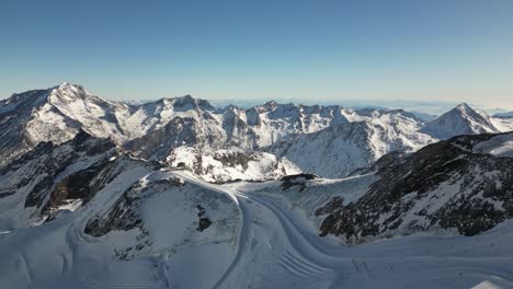 aerial-panoramic-in-the-swiss-alps,-rocky-high-altitude-mountains-with-a-blue-sky