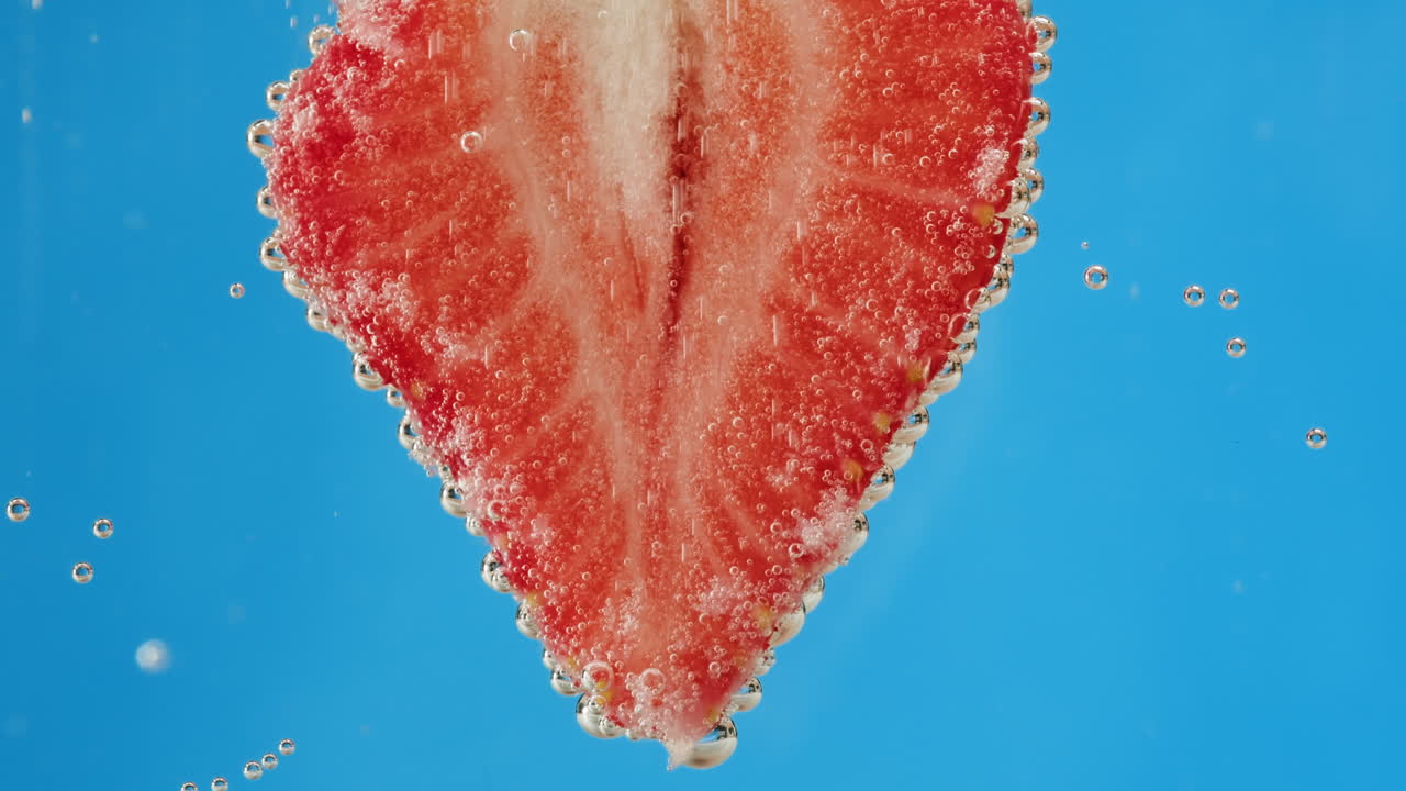 Strawberry slice in water with bubbles