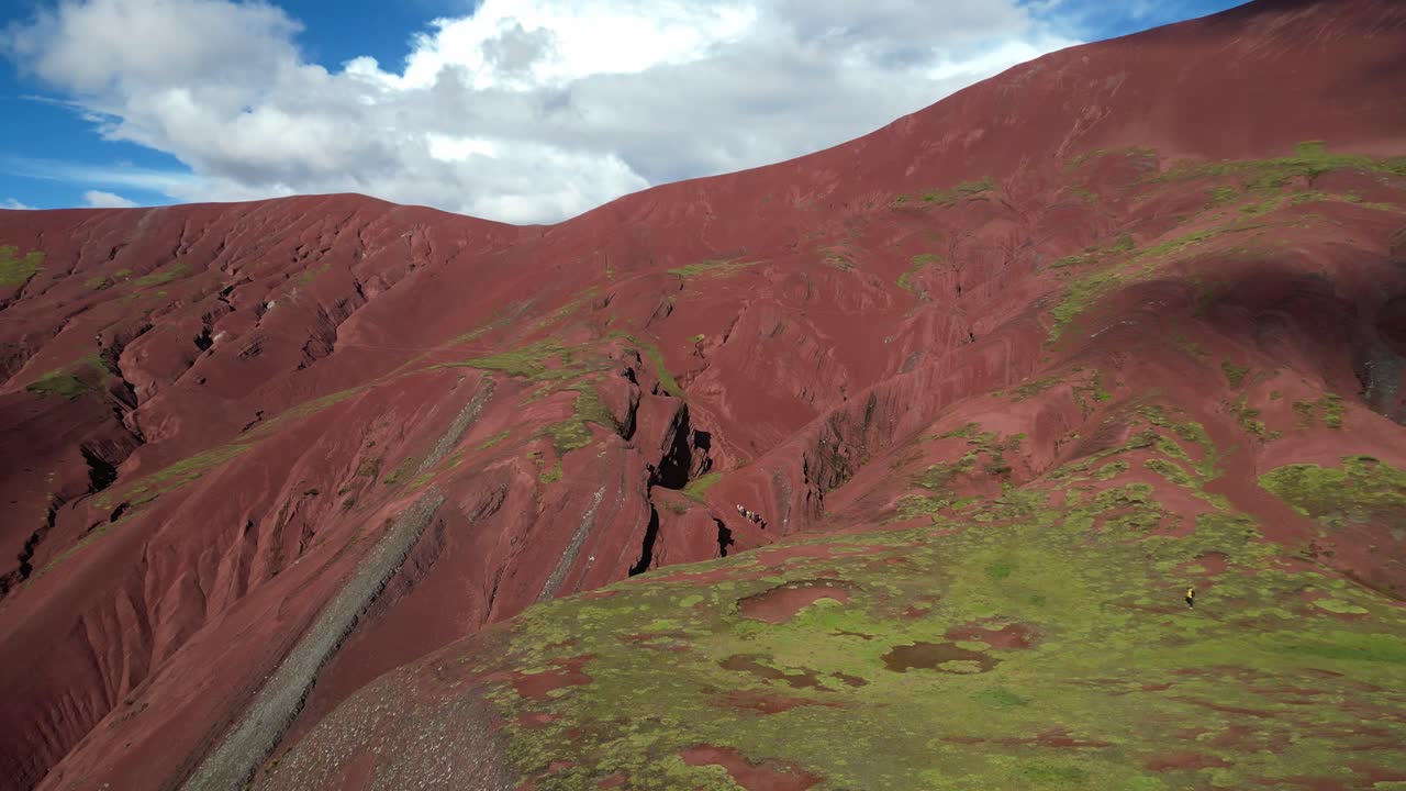 Drone view over the vivid Red Valley in the Andes of Peru. Rugged mountains and surreal colors in pristine, remote nature. Mules carrying luggage