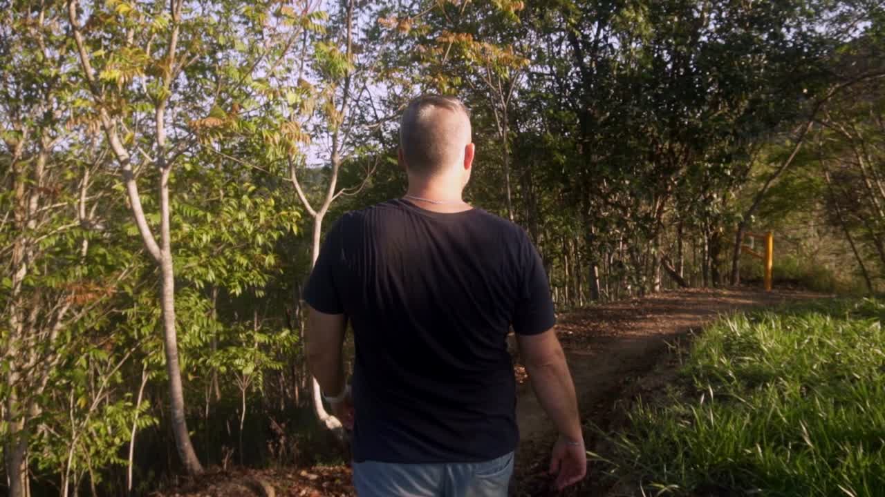man walking along nature trail in slow motion.