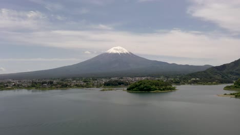 Hermosa-Antena-Del-Icónico-Y-Majestuoso-Volcán-Monte-Fuji-Con-Un-Paisaje-Escénico,-El-Lago-Kawaguchi-Y-El-Pico-Nevado-En-Fuji,-Japón