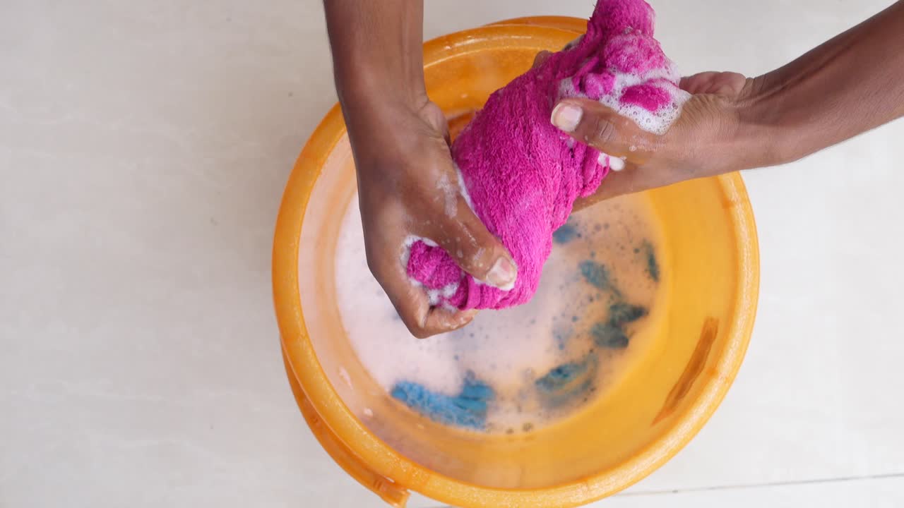 Washing Clothes by Hand in a Bucket