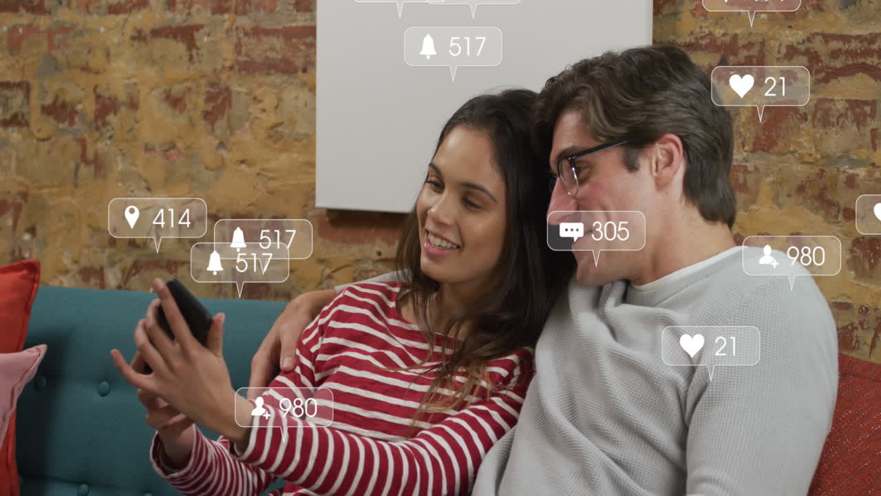 animación de iconos de redes sociales sobre una pareja diversa tomando una selfie desde un teléfono inteligente
