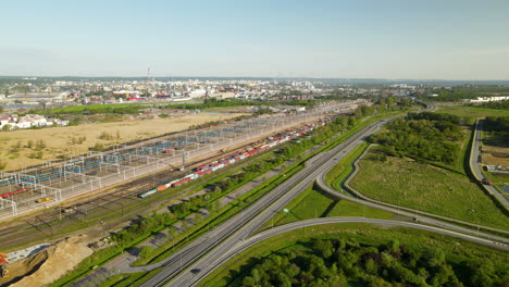 Gran-Depósito-De-Trenes-Con-Muchos-Trenes-De-Carga-Coloridos-Al-Lado-De-La-Carretera-En-Gdansk,-Vista-Aérea-De-Polonia