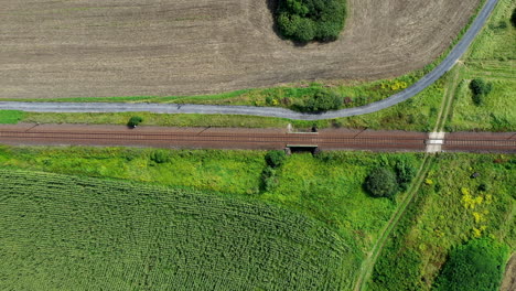 top down shot from train track passing through farm fields