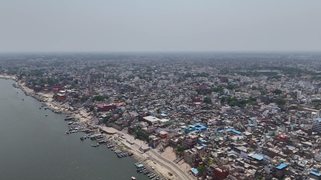 Aerial view of Varanasi ghats during early morning rituals with house near the river