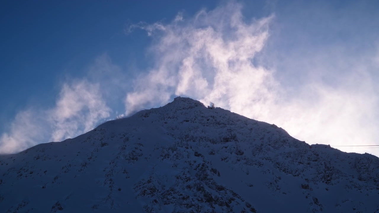 Reaaliaikainen käsivarakuva voimakkaasta lumituiskusta, joka pyyhkii Mont Gelén huipun yli Verbier 4 Valléesissa, Sveitsissä, kovien alppituulten puhaltaessa