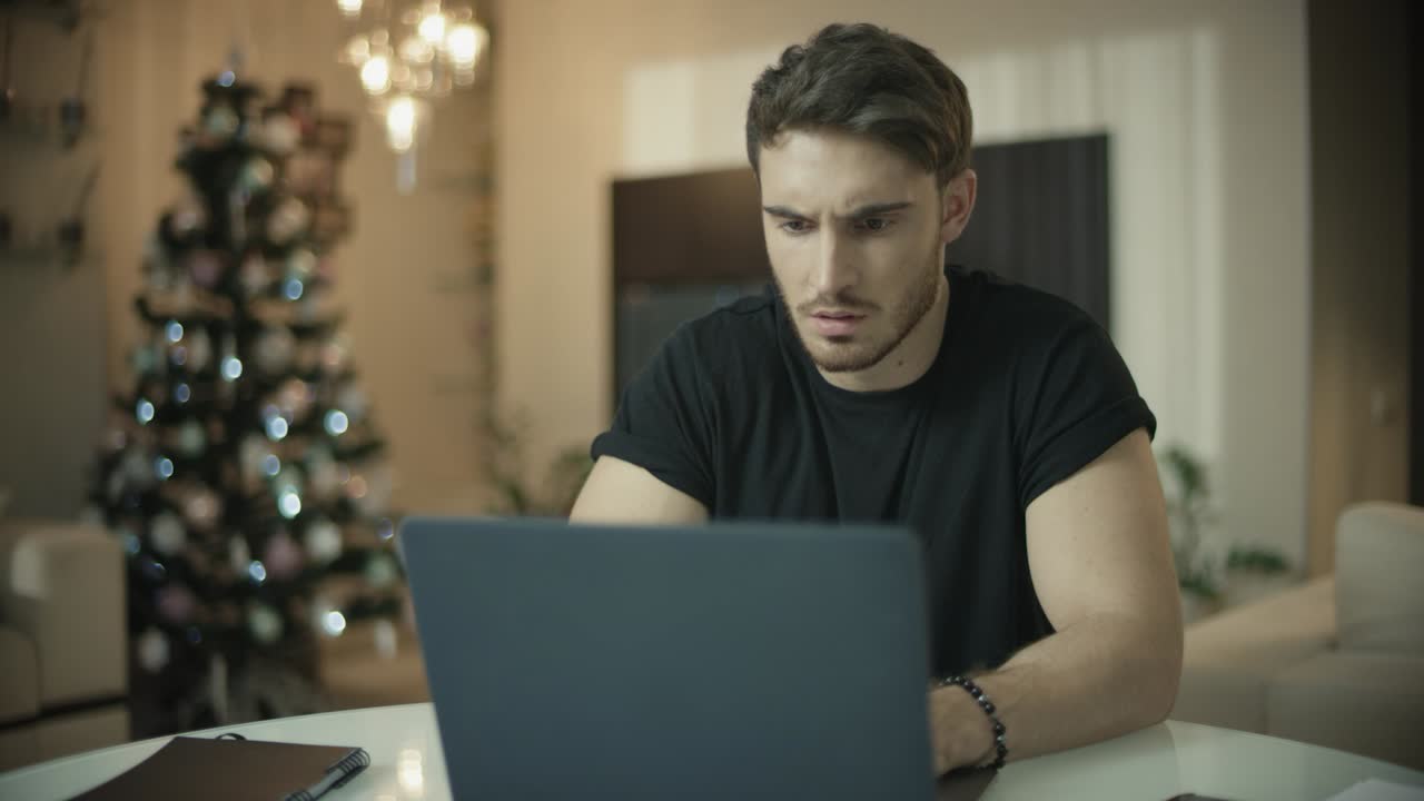 Frustrated man working on laptop computer at home. Annoyed guy have trouble