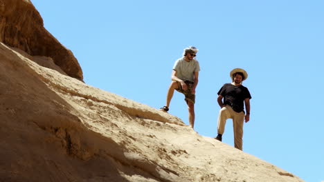 dos hombres de pie en una formación rocosa del desierto