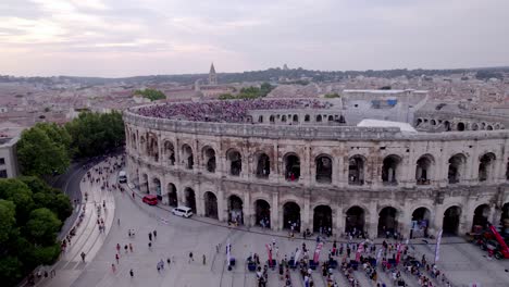 Toma-De-Vista-Aérea-De-Las-Arenas-De-Nîmes-Durante-El-Día-De-La-Gente-Haciendo-Cola-Para-Regresar