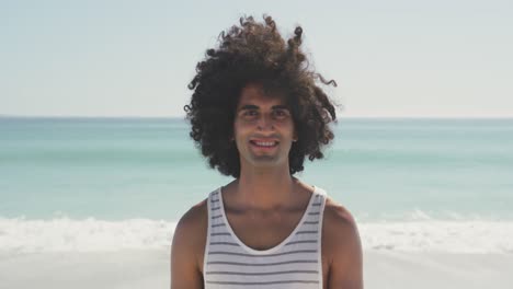 Mixed-race-man-looking-at-the-camera-at-beach-