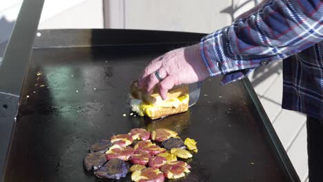 plattieren des gegrillten texas-toast- und ei-sandwiches nach dem grillen auf der flachen grillplatte mit kartoffelbrei