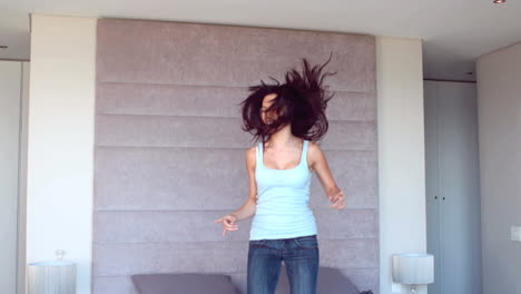 pretty brunette jumping on her bed