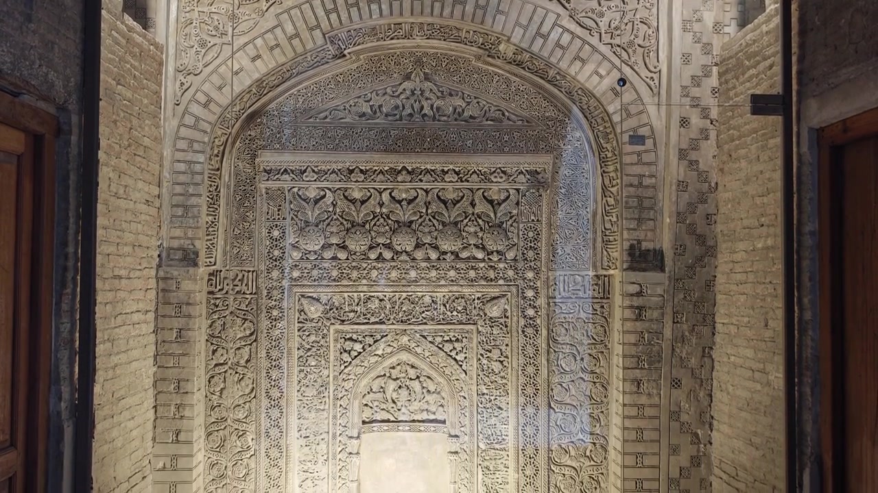 Intricate Stone Carvings on Ancient Islamic Mihrab in Museum