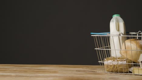 studio shot of basic food items in supermarket wire shopping basket 7