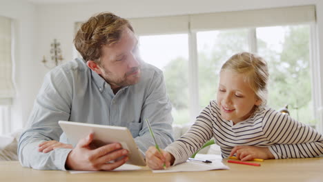 Vater-Hilft-Tochter,-Die-Während-Einer-Gesundheitspandemie-Mit-Einem-Digitalen-Tablet-Am-Tisch-Sitzt