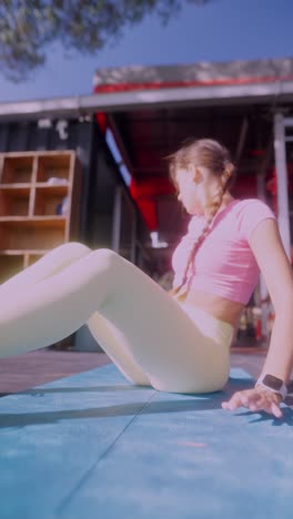 young woman exercising outdoors on a mat