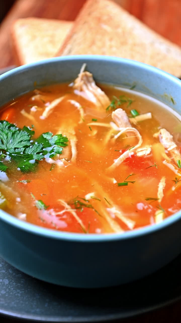 Chicken soup with vegetables and toast. Homemade chicken soup with vegetables and herbs served with bread