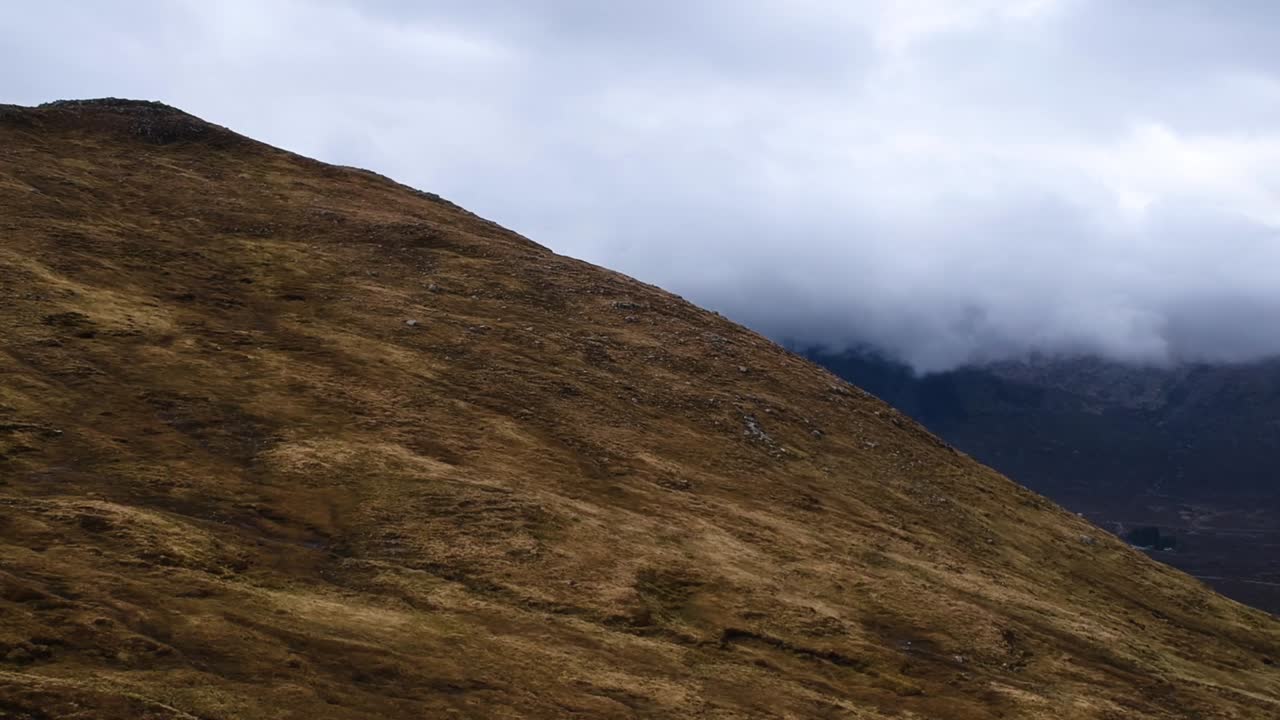 Panoramica cinematografica con drone di montagne delle Highlands nuvolose e nebbiose.