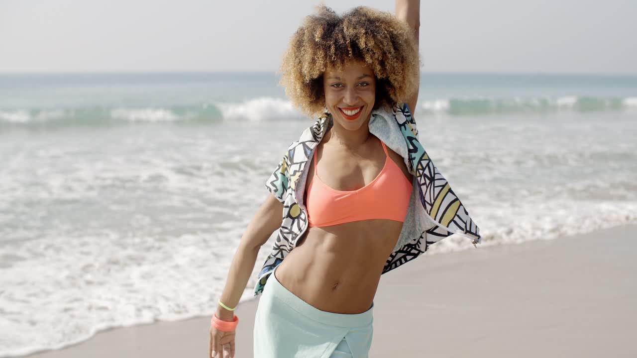 Menina feliz pulando na praia.