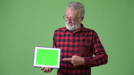 hombre de barba viejo y guapo contra un fondo verde.