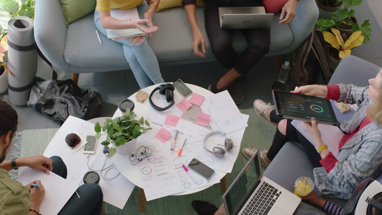 젊은 엔지니어들이 디지털 태블릿 컴퓨터를 사용하여 피트니스 앱 소프트웨어를 개발하고 디자인 솔루션을 브레인스토밍하고 스타트업 사무실 회의에서 아이디어를 공유합니다.