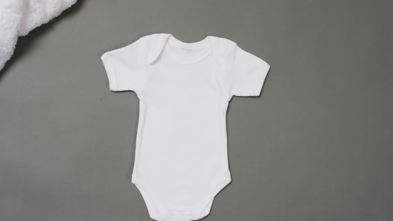 Video of white baby grow with copy space on grey background