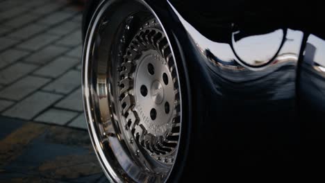 view of the rear axle with a silver shiny wheel disk of a dark new luxury car