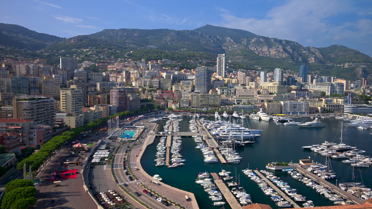 View of boats docked in the Monaco Marina with the skyline of the city on the background