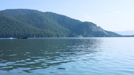 a boat travels across a calm, scenic lake