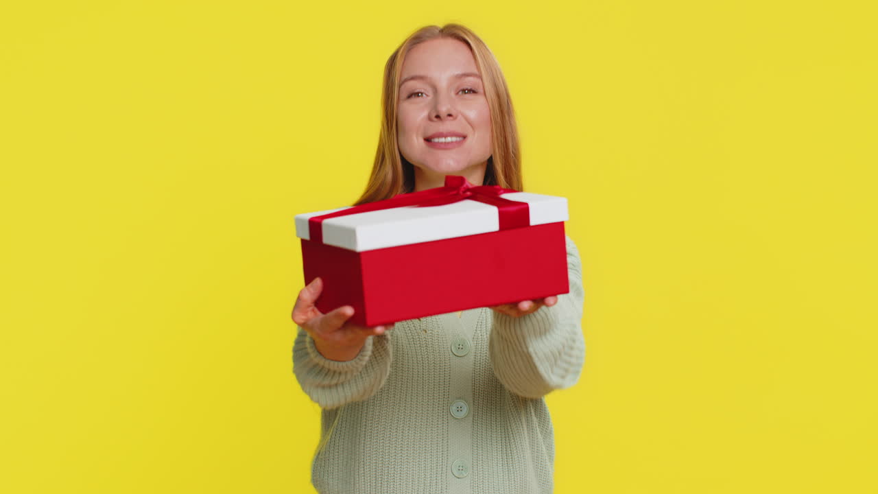 mujer sonriente presentando regalo de cumpleaños caja de regalos extiende las manos promoción venta de descuento