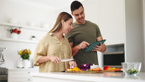 comida, tableta y una pareja cocinando en la cocina