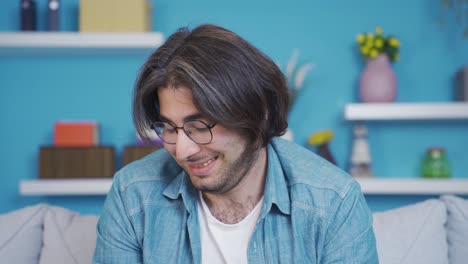 un joven tímido y avergonzado mirando a la cámara.