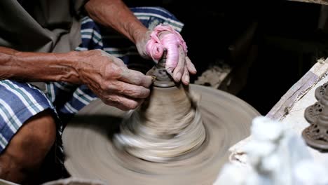 oldman shaving the clay pot lid for perfect shape