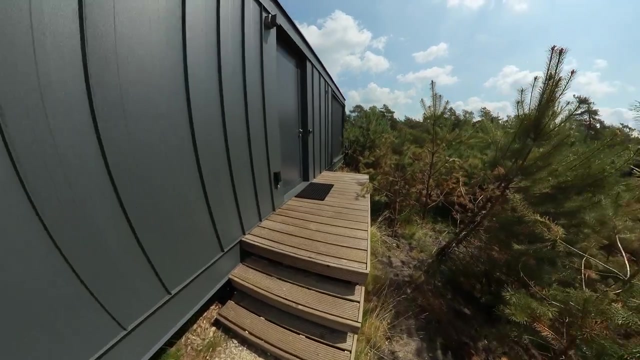 Moderne cabine ecologiche in una foresta serena, che mostrano un'architettura elegante, circondate da una vegetazione lussureggiante, ideali per ritiri nella natura, vita sostenibile e fughe tranquille