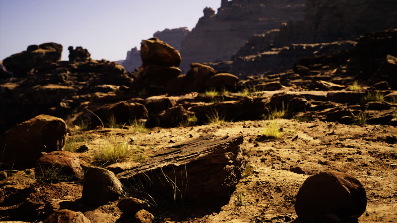 Rocky desert landscape with natural formations and sparse vegetation at sunset