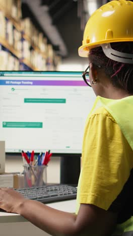 vertical video african american female working in logistics hub with tracking info