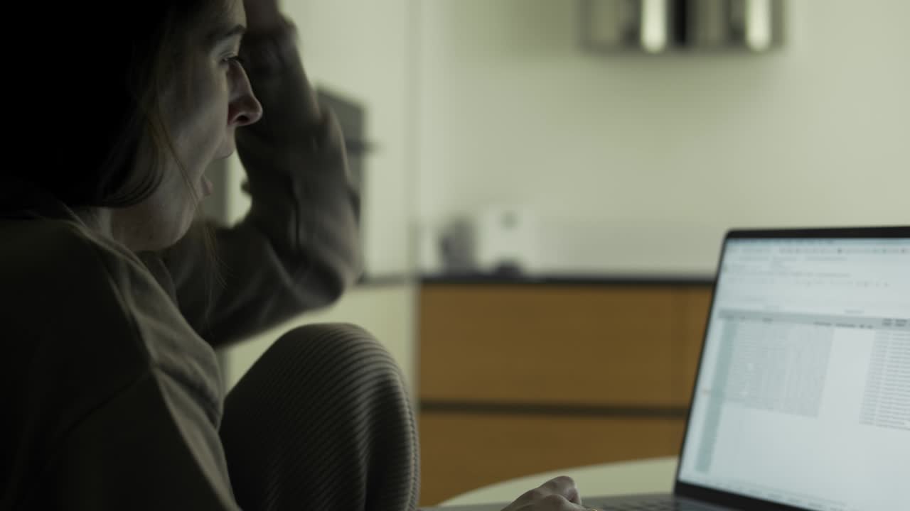 mujer trabaja con computadora portátil en casa tarde en la noche