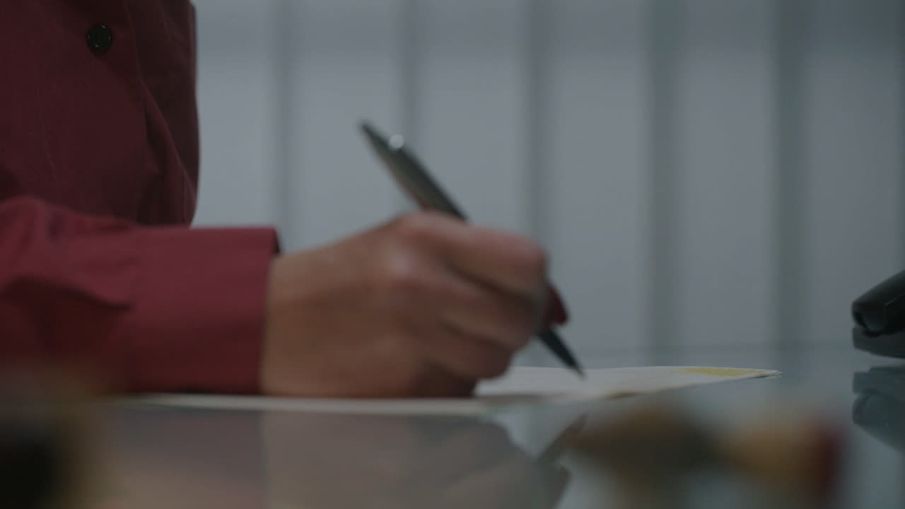 Person writing on paper at a desk