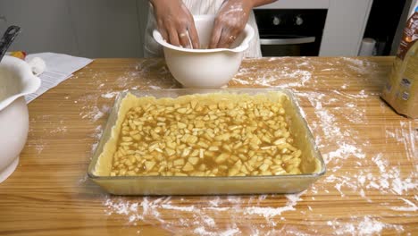 married female preparing crumble pie topping in domestic kitchen