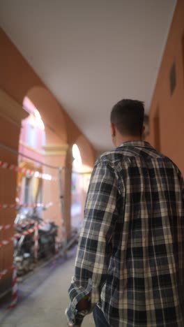 man walking in an urban arcade
