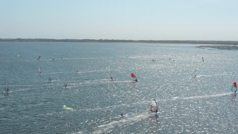 drone - aerial shot of many surfers on a blue, wavy and windy sea on a sunny day with white clouds on a island, zeeland, netherlands, 25p