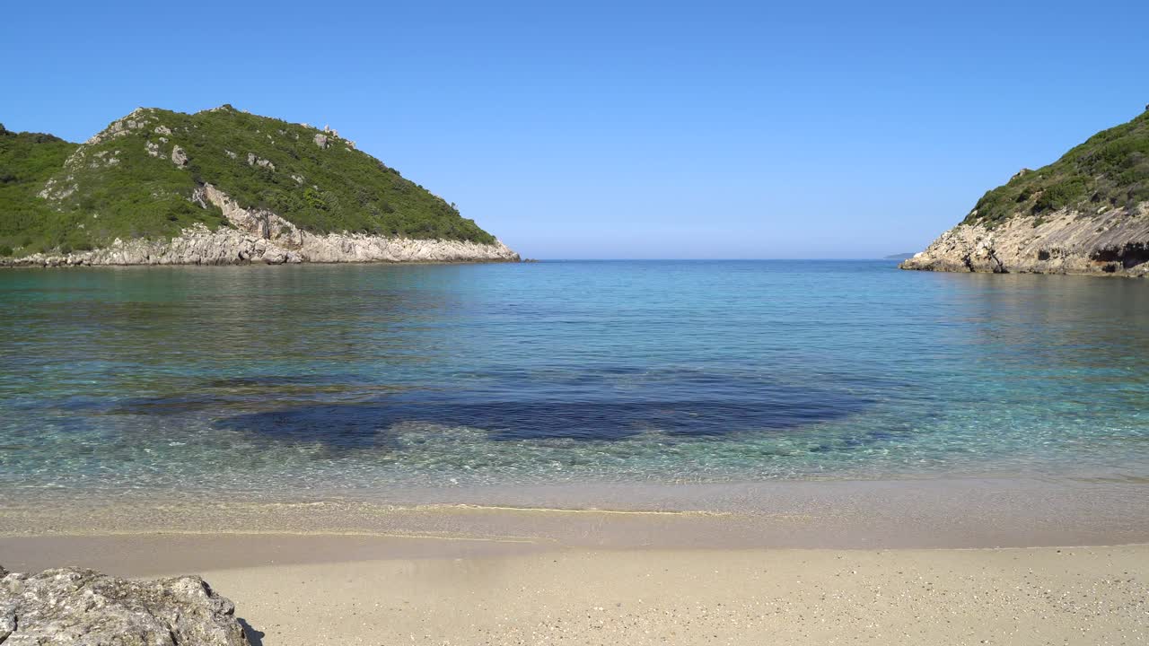 Sanfte Schwenkaufnahme des kristallklaren Wassers, das den Strand von Porto Timoni auf der Insel Korfu umspült