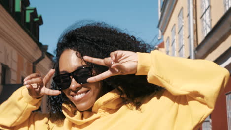 young woman in a yellow hoodie posing in the city