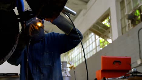 Mechanic-using-wielding-torch-on-a-car-in-garage-4k